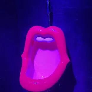a pink urinal with a tongue sticking out of it