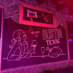 a neon drawing of a woman sitting at a bar