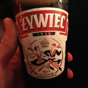 a hand holding a bottle of beer