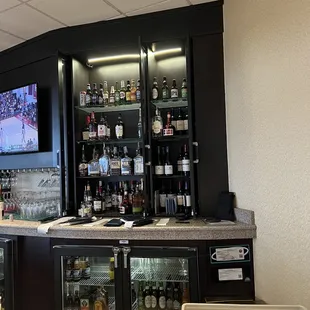 a bar area with a television and wine coolers