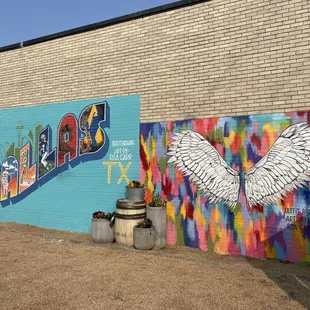 a colorful mural of wings on the side of a building