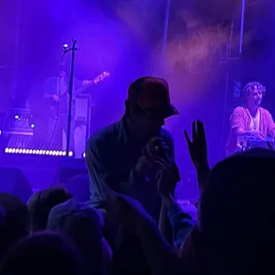 Revivalists singer singing and shaking hands with the crowd