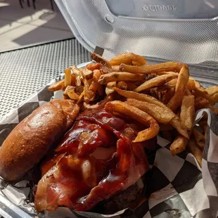 Cowboy burger (bacon, 1 slice brisket, and a thick beef patty) with fries.