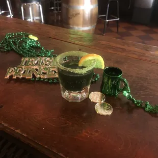 a shot of a green drink with a slice of lime