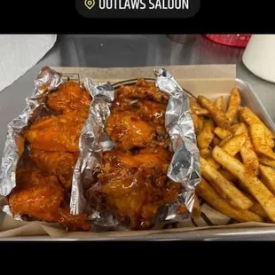 chicken wings and french fries in a box