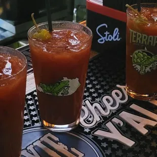 three glasses of bloody drink on a bar