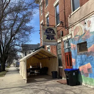 a tent set up in front of a building