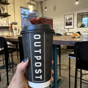 a person holding a cup of coffee