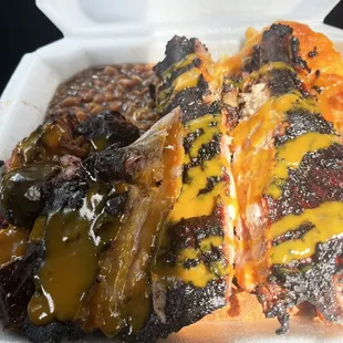 barbecued meat and beans in a styrofoam container
