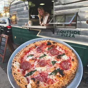 a person holding a plate of pizza