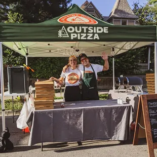 a man and a woman standing under a tent