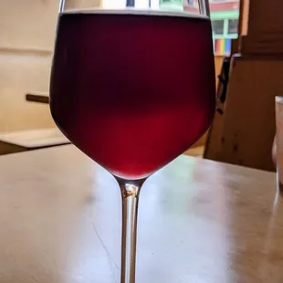 a glass of red wine on a table