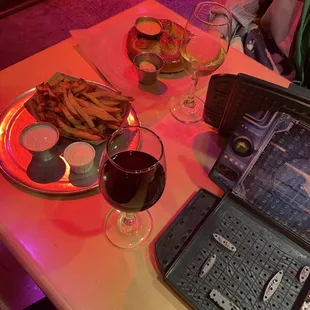 a table with a laptop and a glass of wine