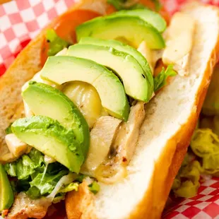 a hot dog with avocado and pickles