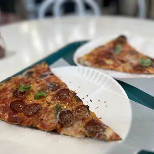 Pepperoni topped with fresh basil, Parmesan, and red pepper flakes
