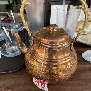 a copper teapot on a table