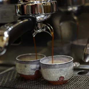 coffee being poured into two cups
