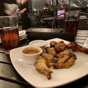 a plate of chicken wings and dipping sauce