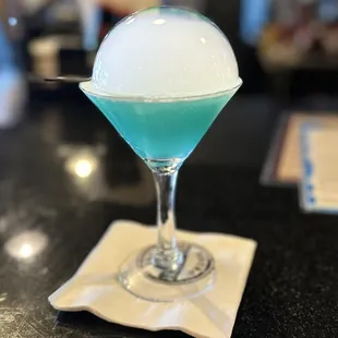a blue cocktail with ice