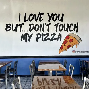 a restaurant with a pizza on the wall