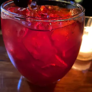 a red drink with a cherry garnish