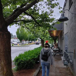 a woman walking down a sidewalk