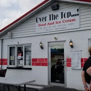 a man and a woman standing in front of a restaurant