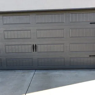 New charcoal gray bead board garage door with fancy black hardware.