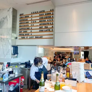a restaurant counter with a menu on the wall