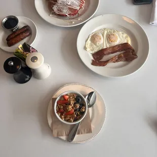 a breakfast of eggs, bacon, tomatoes, and sausage