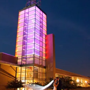 Newlyweds below the Icon Tower lit in their wedding colors!