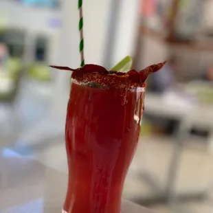 a bloody drink with bacon and a garnish