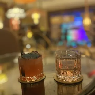 two cocktails on a glass table