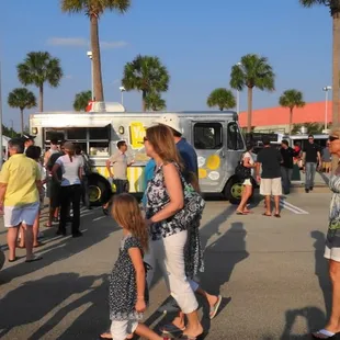 a crowd of people and trucks