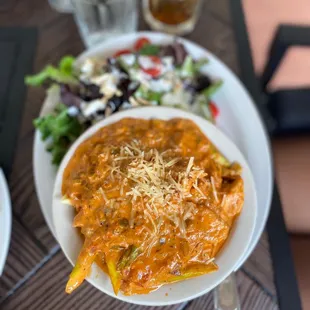 a bowl of pasta and a salad