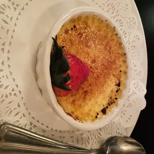 a bowl of creme with a strawberry on top