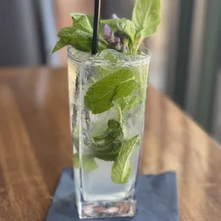 a mojit with mint leaves and a straw