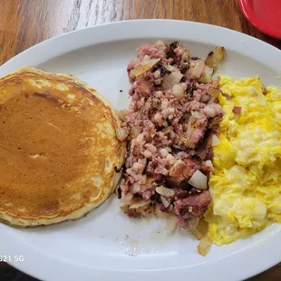 Corned beef hash, eggs scrambled soft with cheese and a pancake.