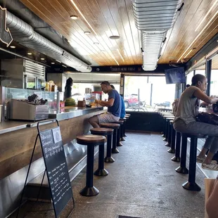 people sitting at a counter in a restaurant