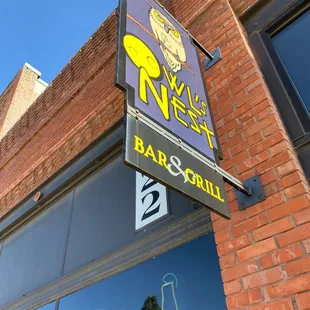 a brick building with a sign for a bar and grill