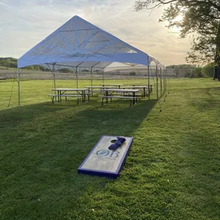 a corn hole and picnic tables