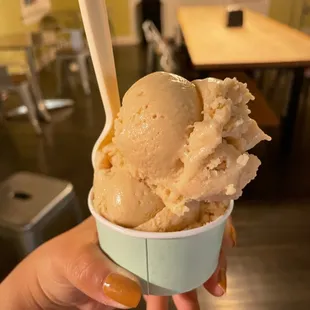 a hand holding a cup of ice cream