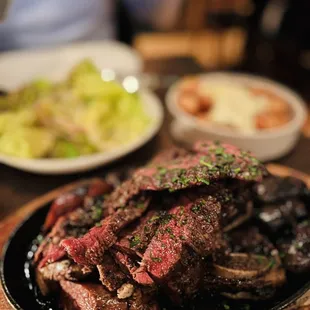 a steak on a plate with a side of salad