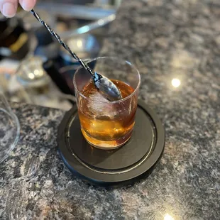 a glass of whiskey with a spoon sticking out of it