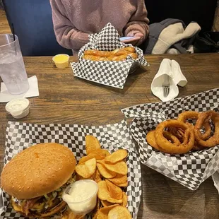 a woman sitting at a table with two trays of food