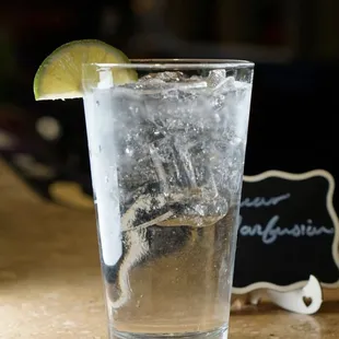 a glass of water with a lime wedge