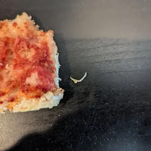 Fingernail is pictured in the center, with the now cheese-less pizza to the left