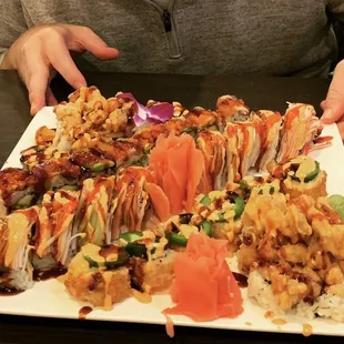a person holding a plate of sushi