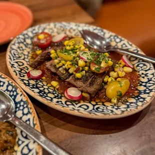 ARRACHERA CON SALSA JITOMATE Grilled flank steak served with salsa jitomate, grilled corn pico de gallo, and radishes