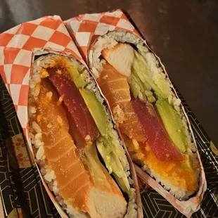 two hotdogs with avocado and cheese